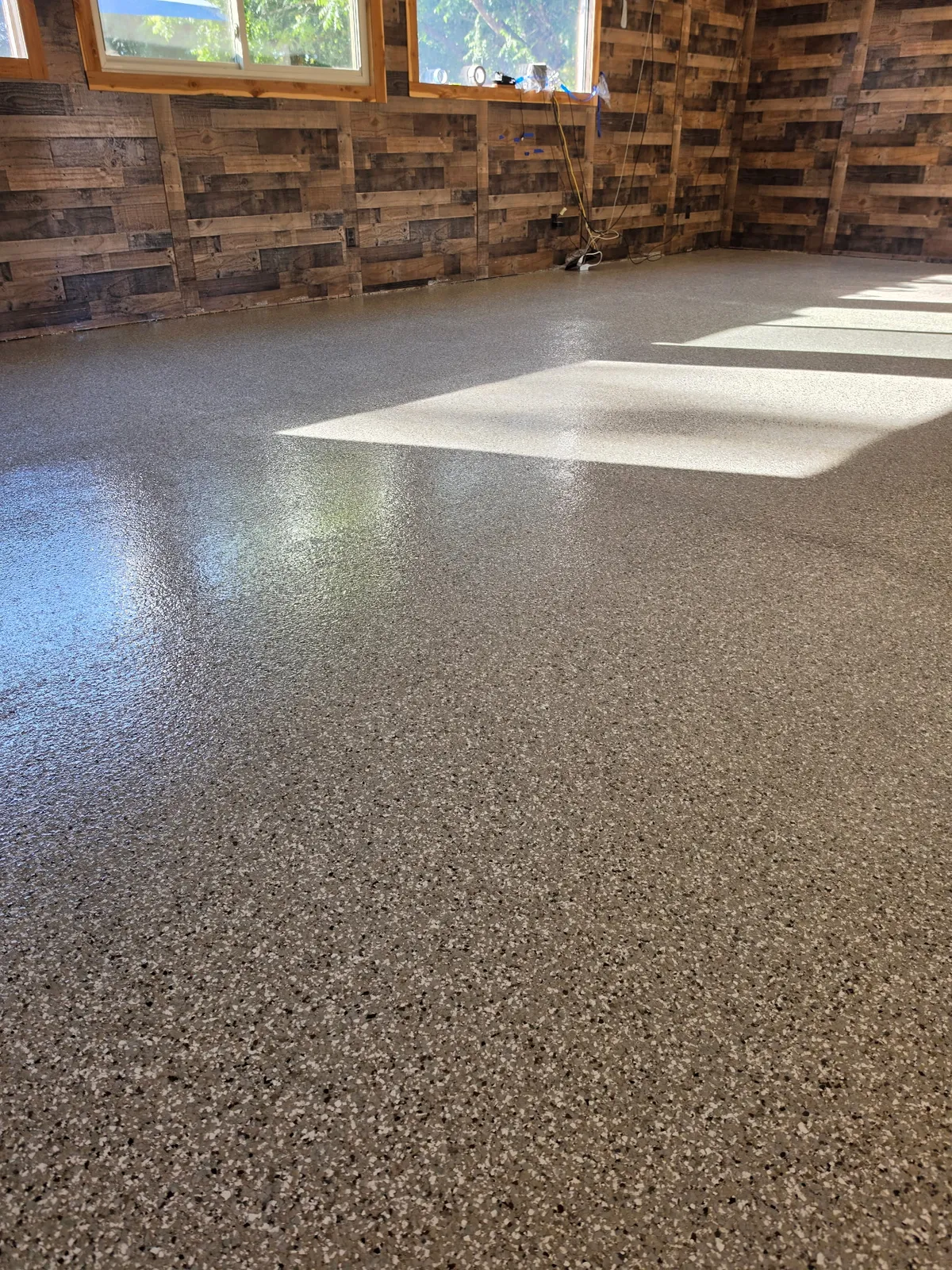 Twin Lakes Epoxy full-flake floor installation at Rocking Chair Resort game room showing pool cue rack and high-gloss finish