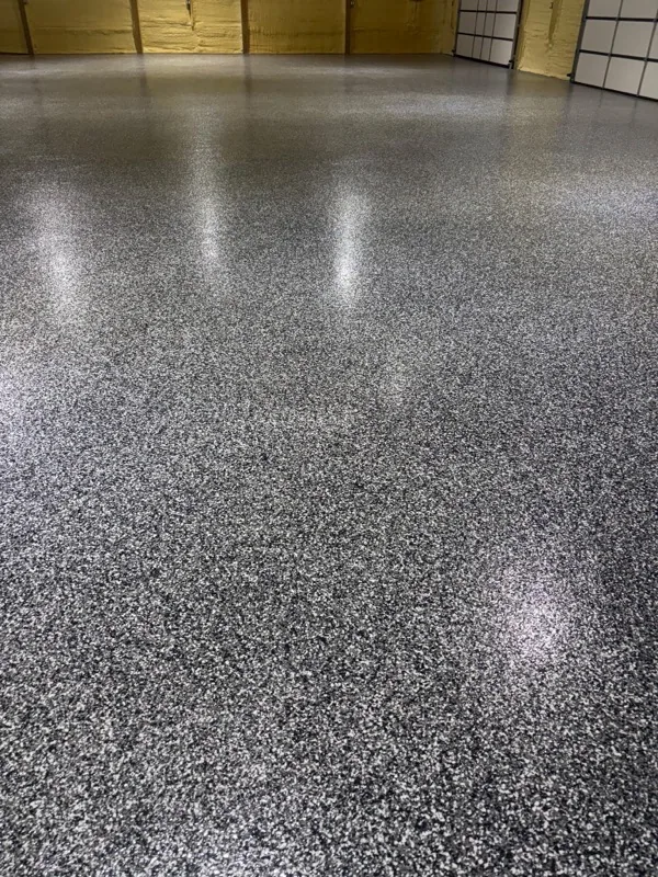 Low-angle view of the glossy gray full-flake epoxy shop floor